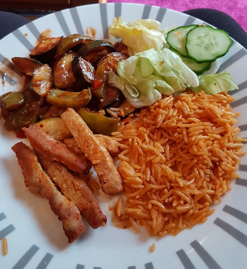 Peri Peri Pork strips on a plate with rice salad and ratatouille