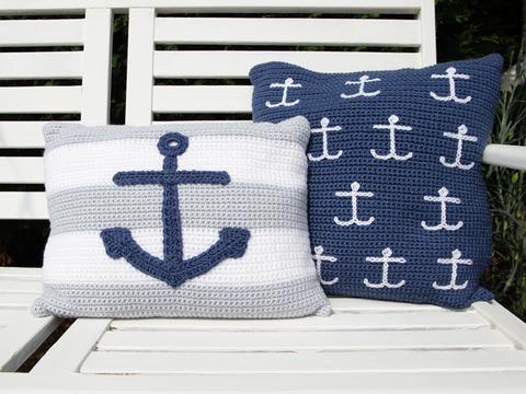 image shows both the square striped cushion with a large anchor and the blue cushion with small white anchors.