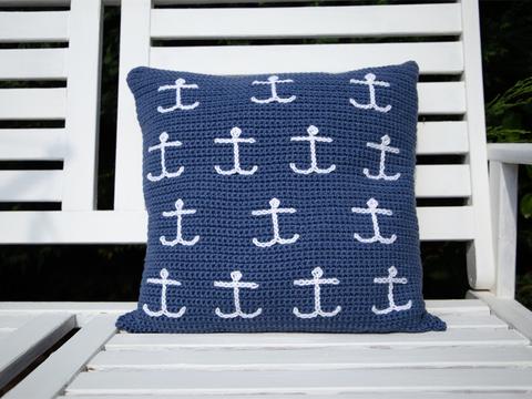 image shows a dark blue cushion with mini white anchors