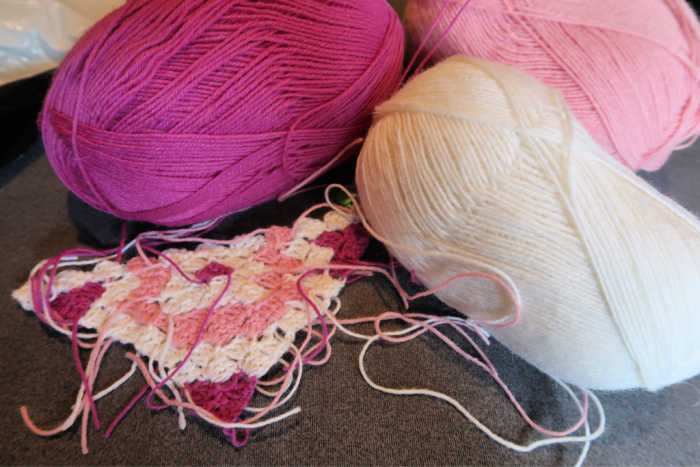 another crochet works in progress, the other side of the cushion and three balls of wall, in white pink and dark pink