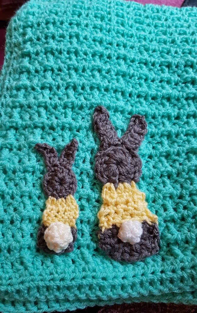 baby blanket crochet in waffle stitch, with two little bunnies sewn on