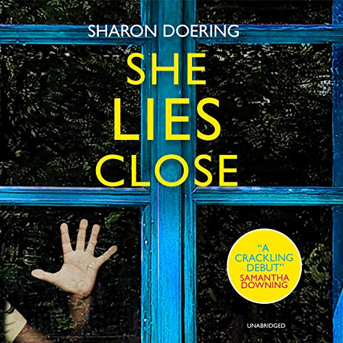 She Lies Close, book cover. a child's hand an be seen behind a blue framed window.